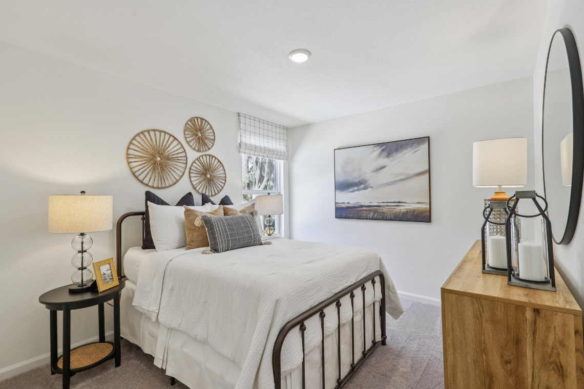 A bedroom with a bed and lamps.