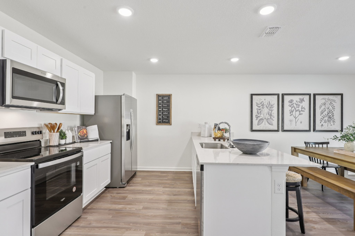 A kitchen with white cabinets.