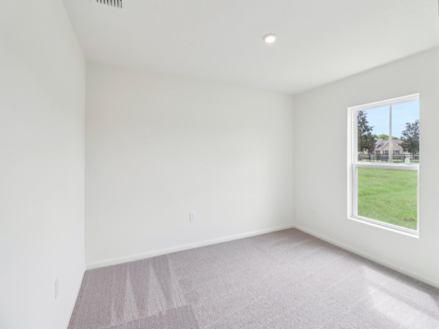 A room with a window and a carpet.