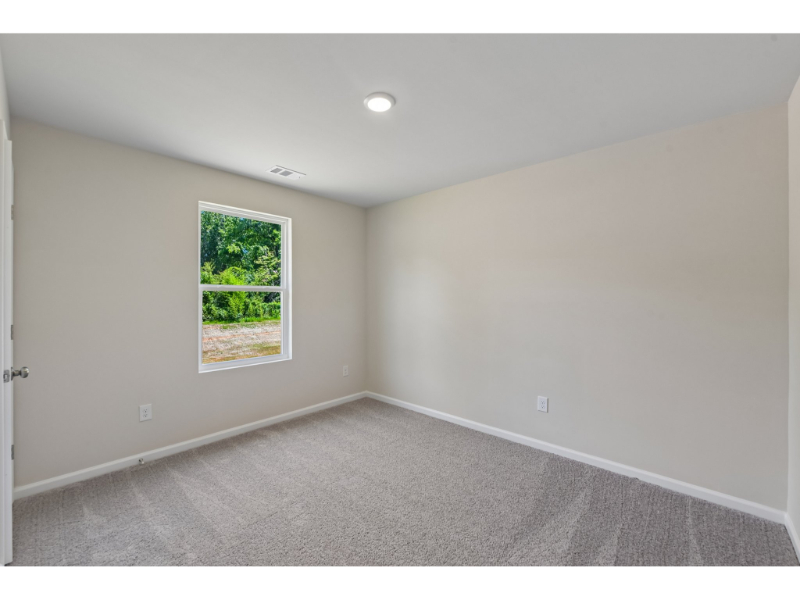 A room with a window and a carpet.