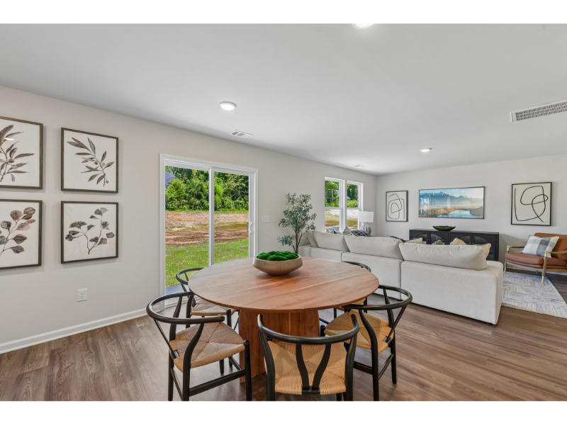 A living room with a table and chairs.