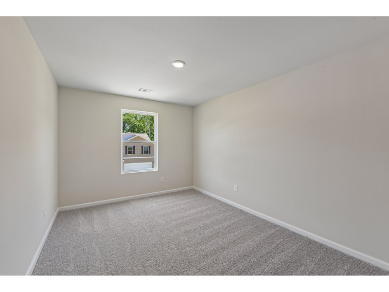 A room with a window and a carpet.