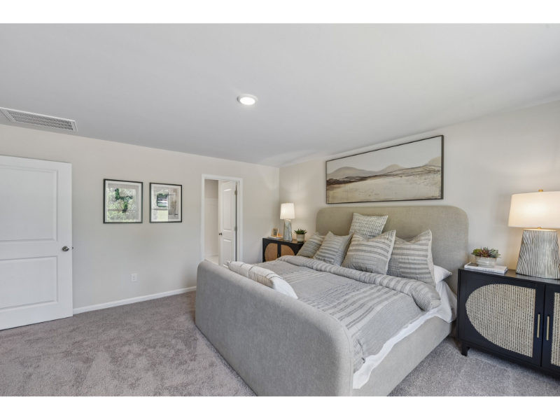 A bedroom with a bed and lamps.