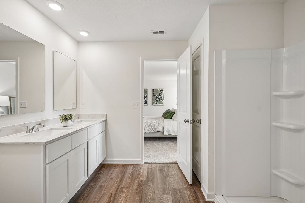 A bathroom with white cabinets.