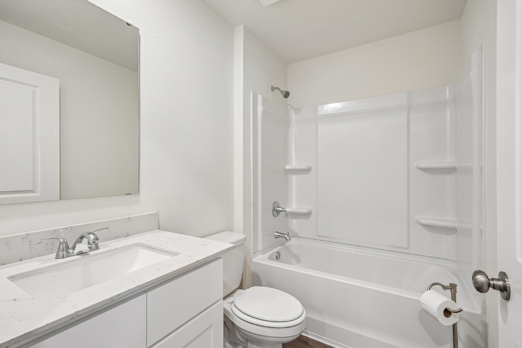 A bathroom with a tub sink and toilet.