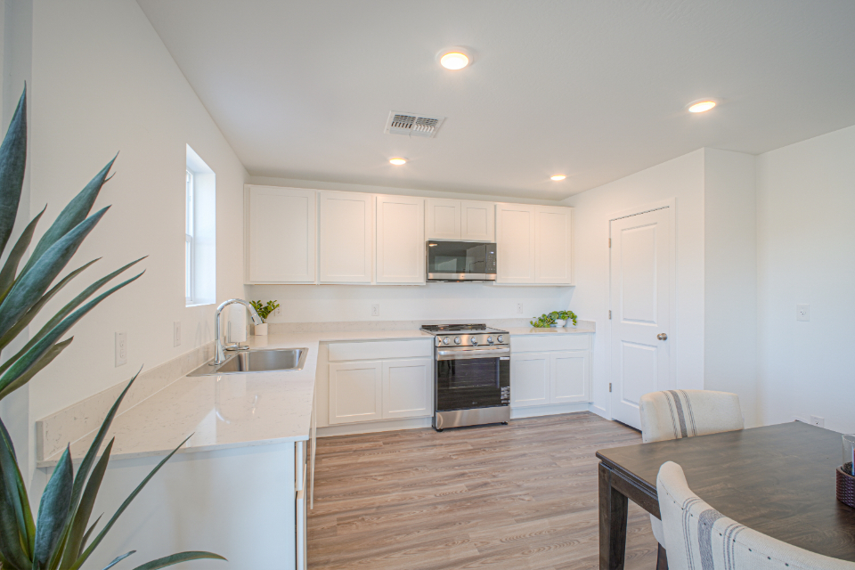 A kitchen with white cabinets.