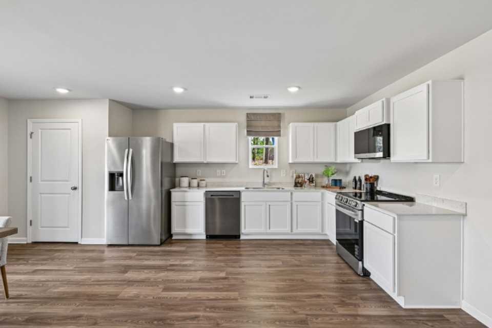 A kitchen with white cabinets.