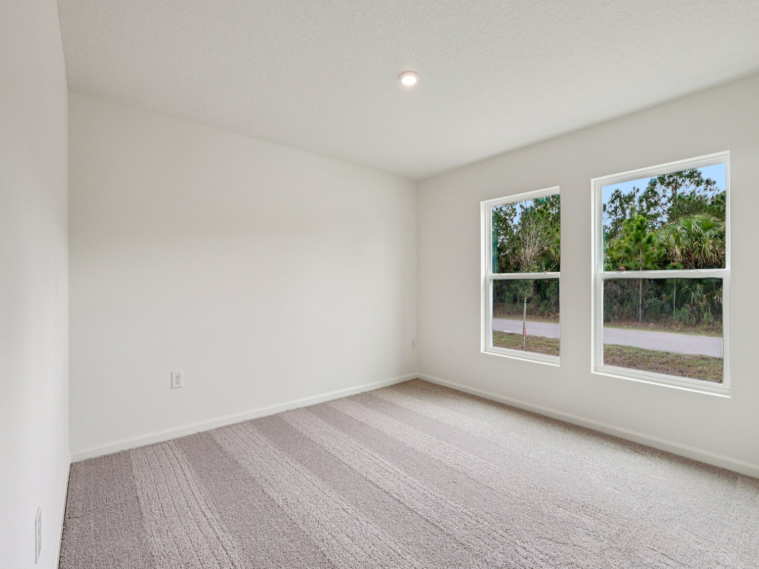A room with a window and a rug in it.