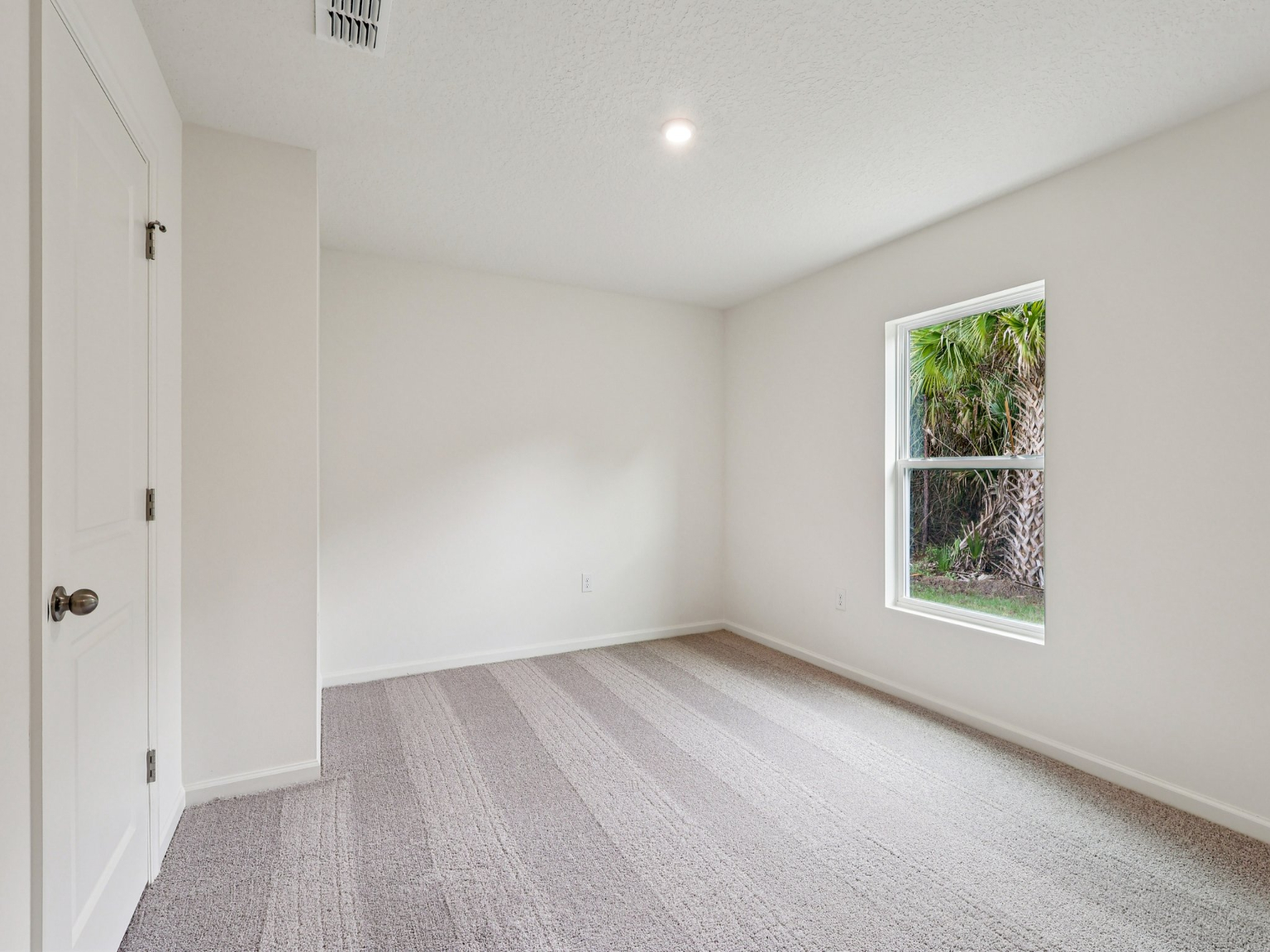 A room with white walls and a window.