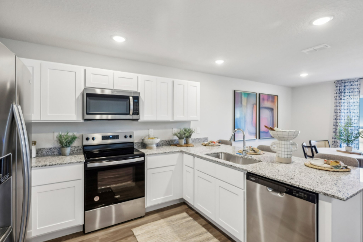 A kitchen with white cabinets.