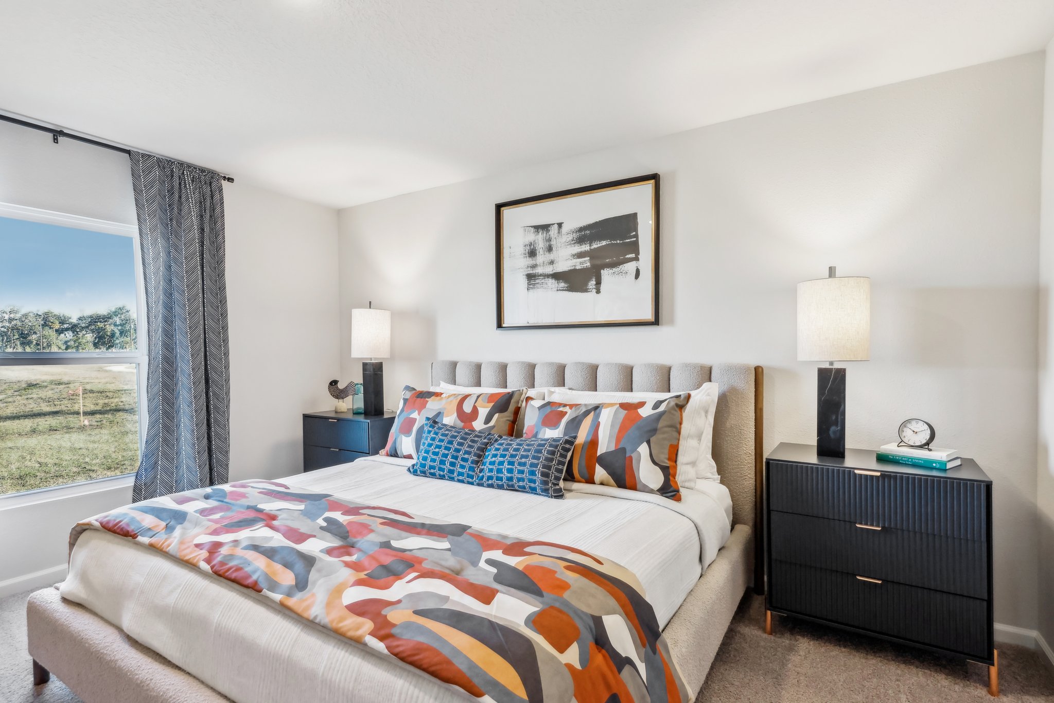 A bed with a colorful blanket.