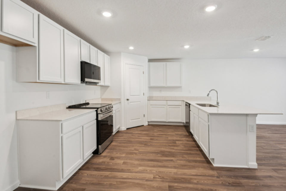 A kitchen with white cabinets.