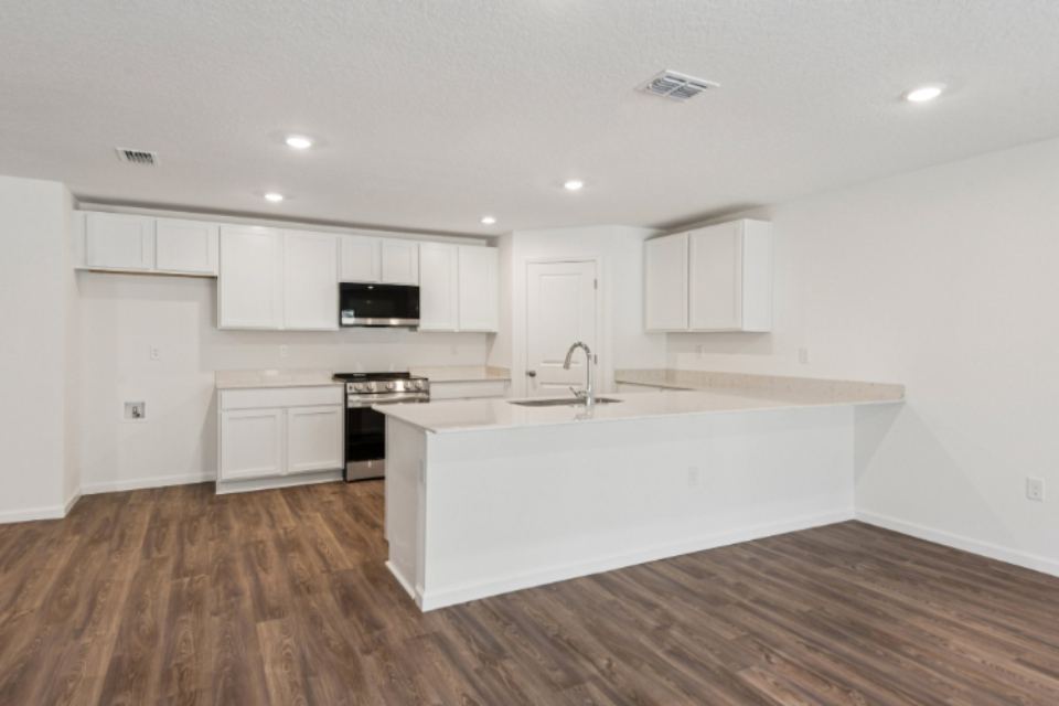 A kitchen with white cabinets.