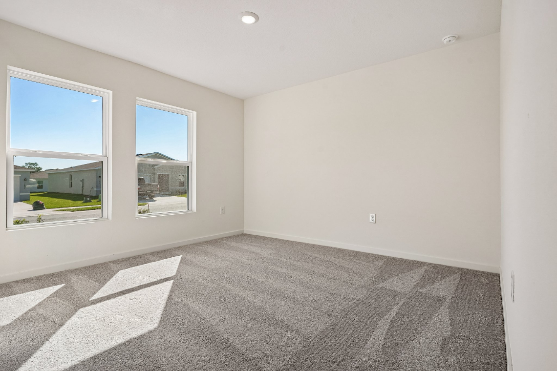 A room with a window and a rug.