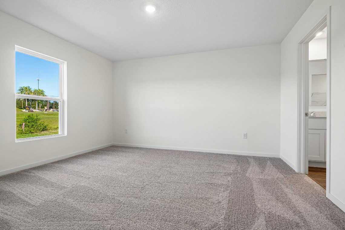 A room with a carpet and a window.