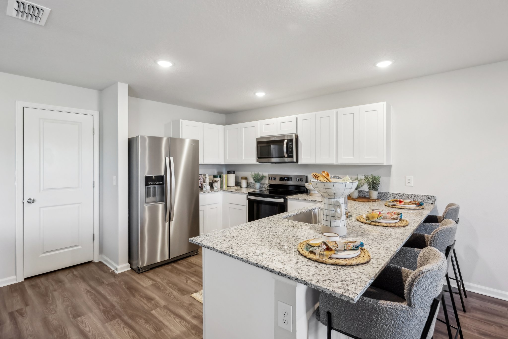 A kitchen with white cabinets.