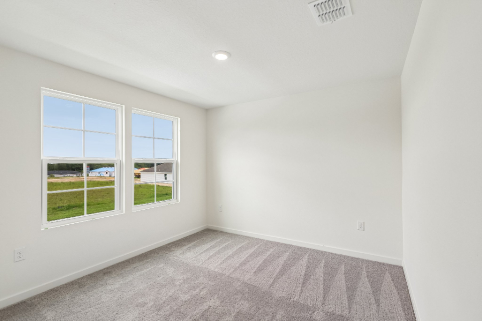 A room with a carpet and windows.
