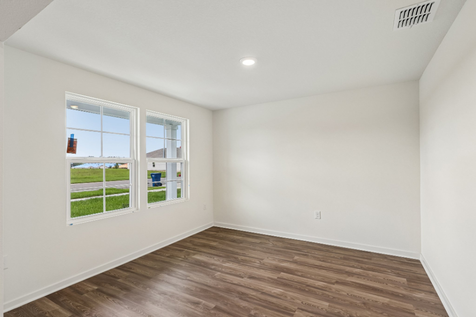 A room with a wood floor and windows.