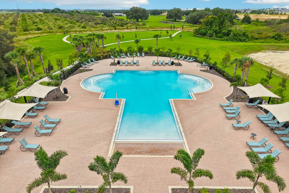 A pool surrounded by lounge chairs.