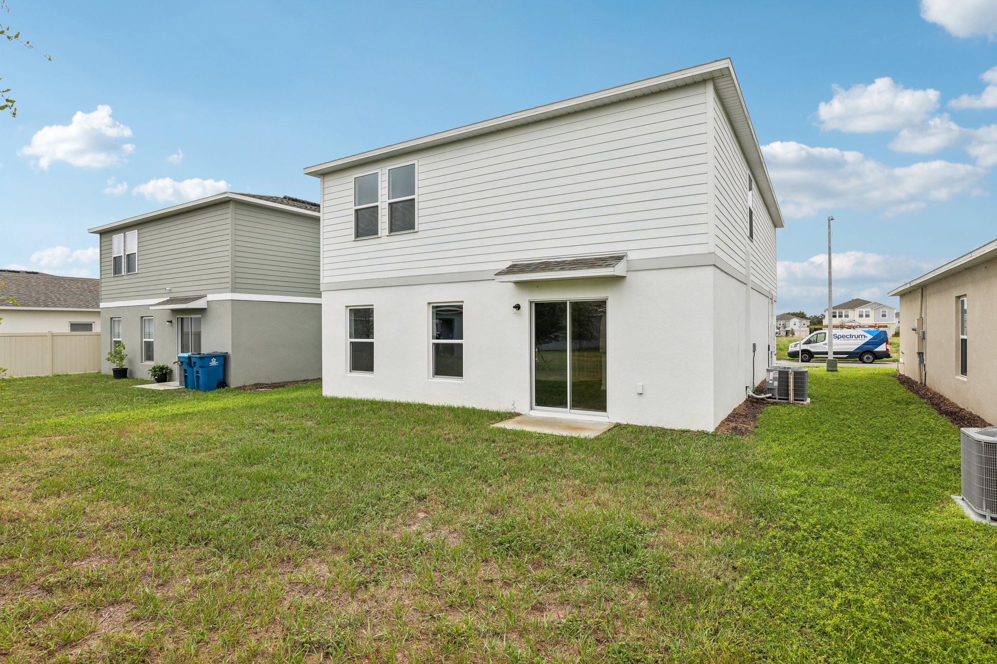 A white house with a green lawn.