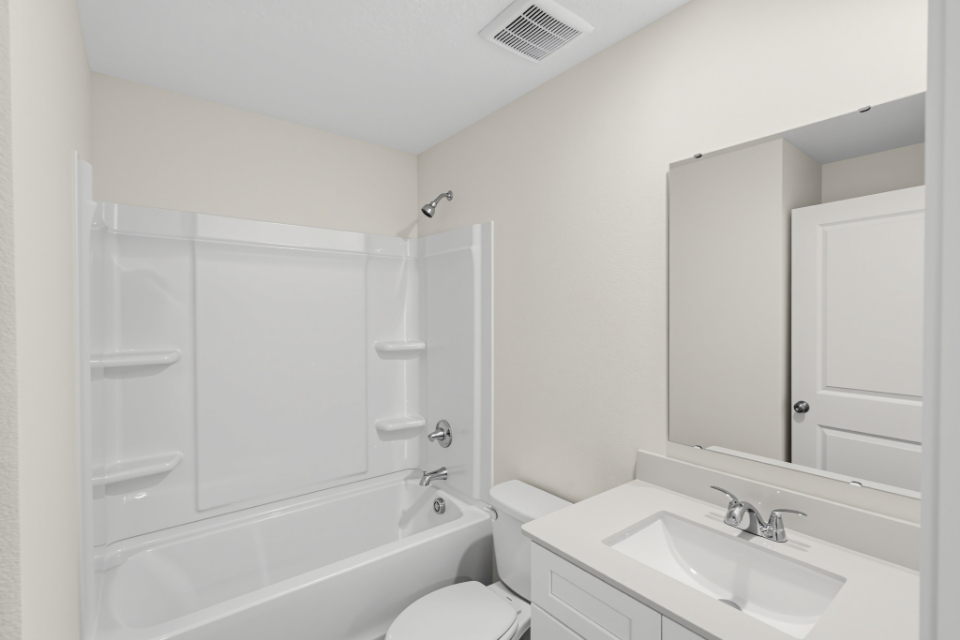 A bathroom with a tub sink and toilet.
