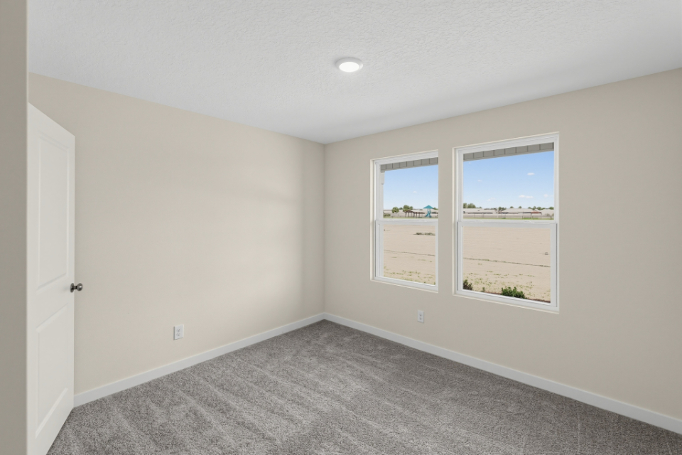 A room with a window and a carpet.