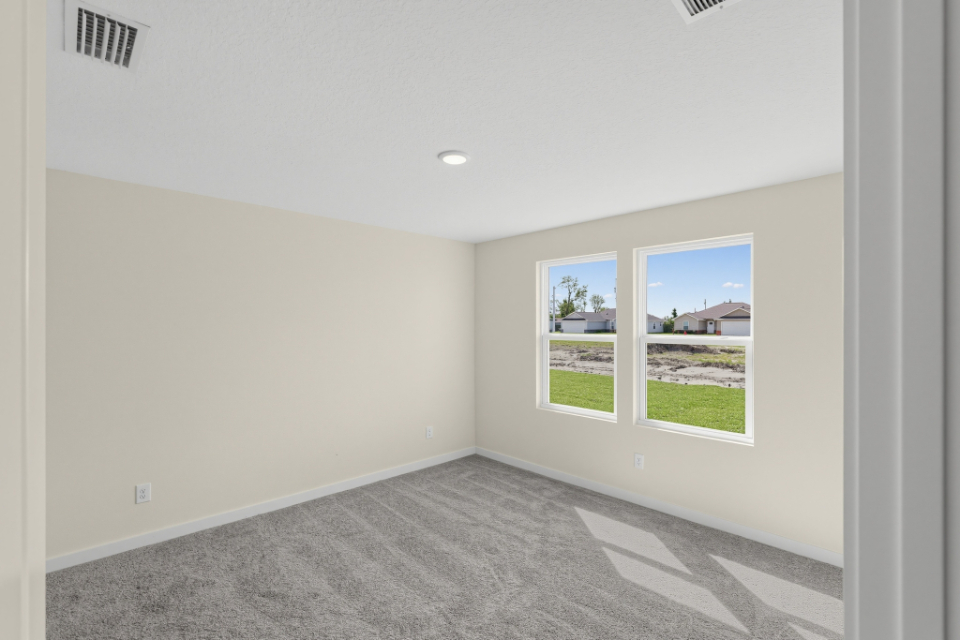 A room with a window and a door with a view of the yard.