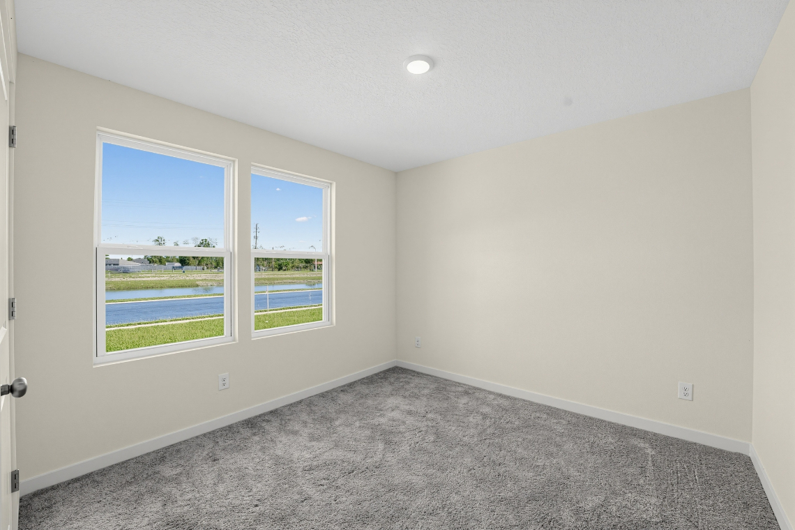 A room with a window and a carpet.