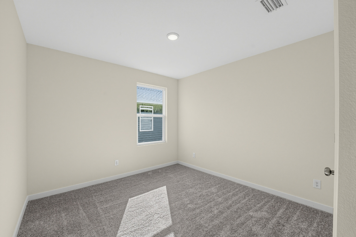 A room with a rug and a window.