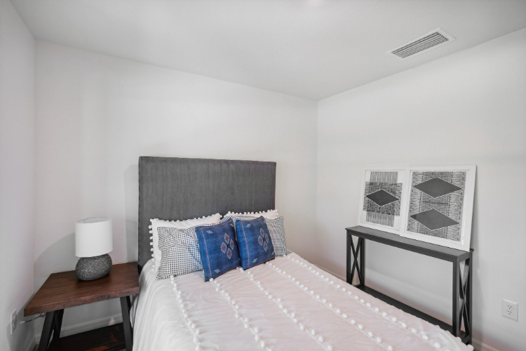 A bed with a white wall.