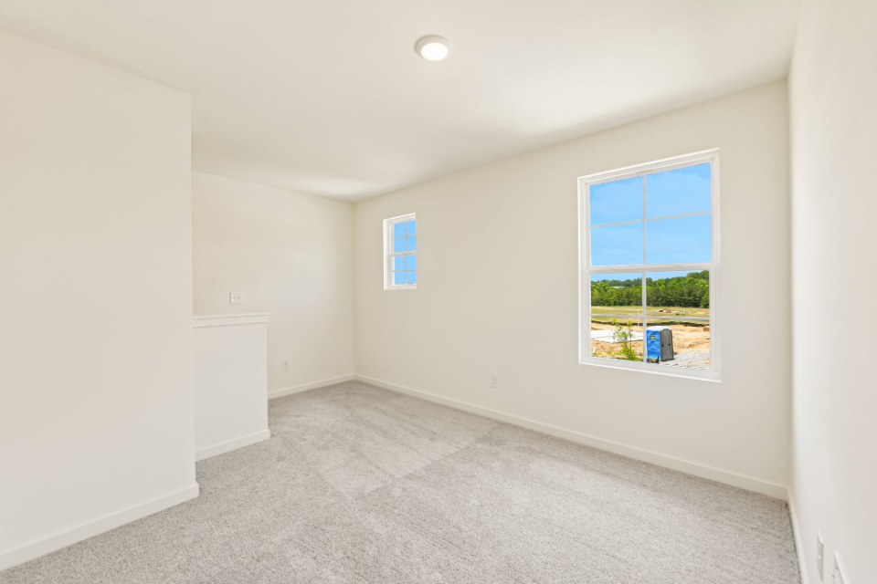 A room with a window and a carpet.