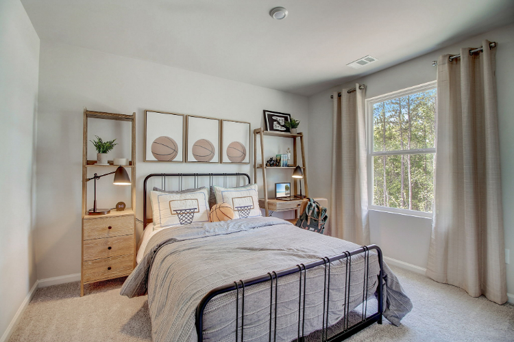 A bedroom with a bed and a shelf with pictures on it.