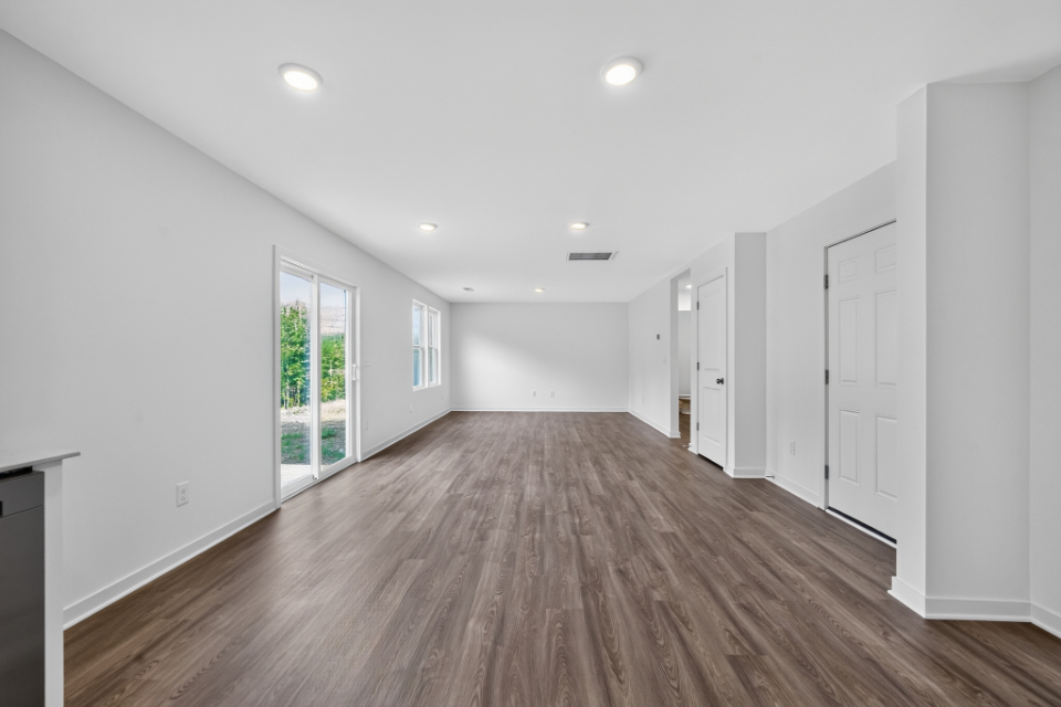 A room with white walls and wood floors.