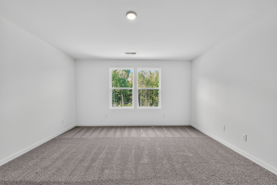A room with a window and a white wall.
