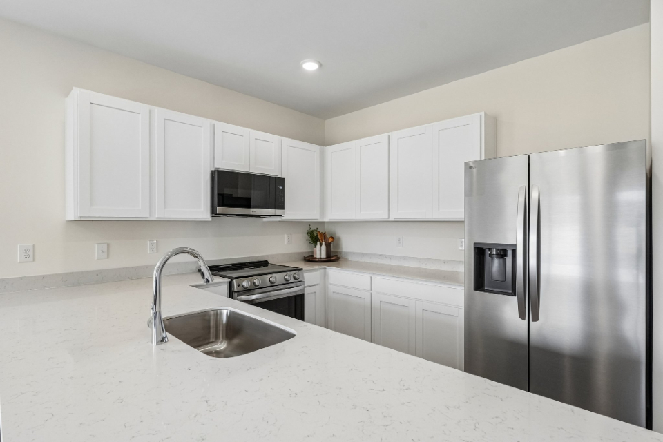 A kitchen with white cabinets.