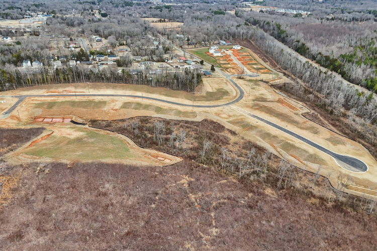 A road with a field and trees.