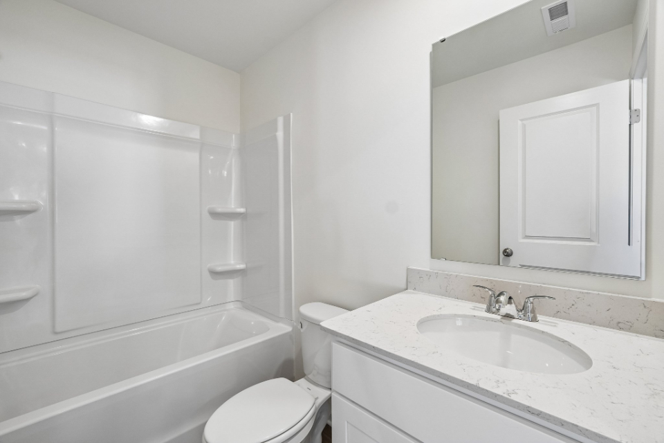 A bathroom with a sink toilet and bathtub.