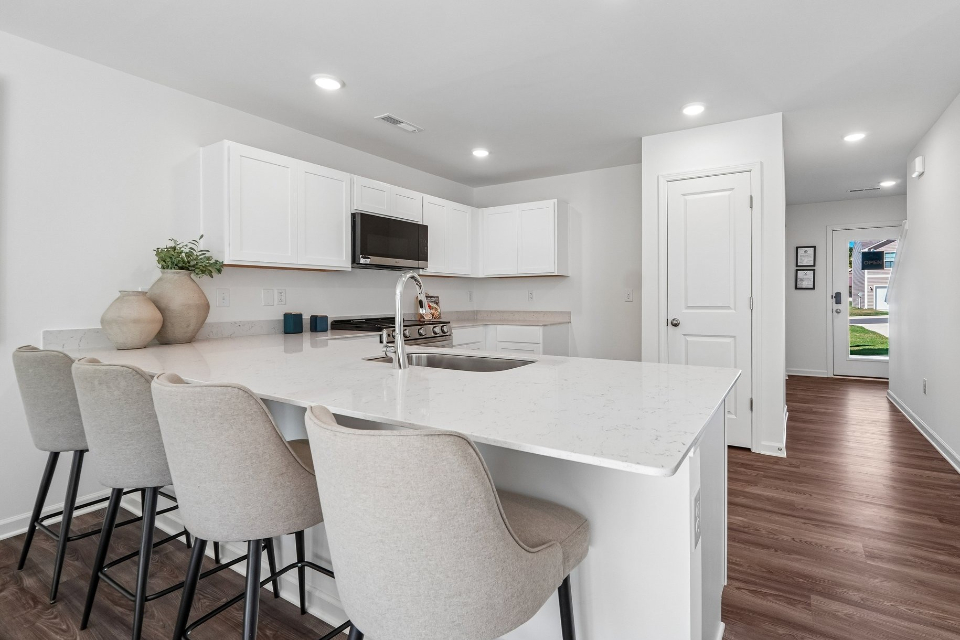 A kitchen with a white table and chairs.