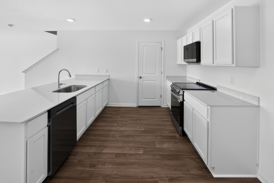 A kitchen with white cabinets.