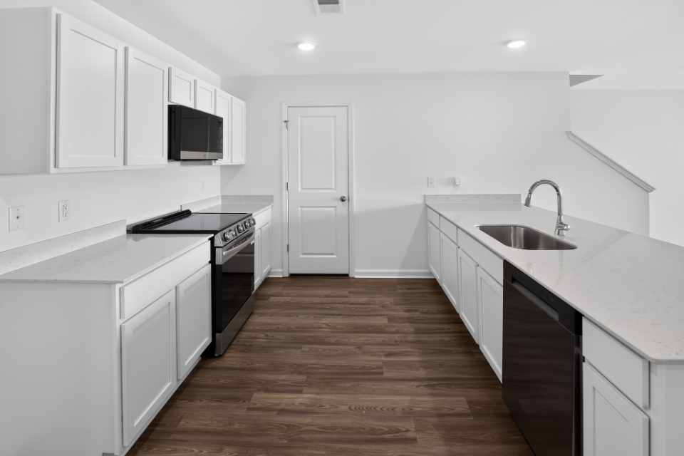 A kitchen with white cabinets.