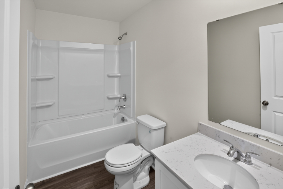 A bathroom with a tub sink and toilet.