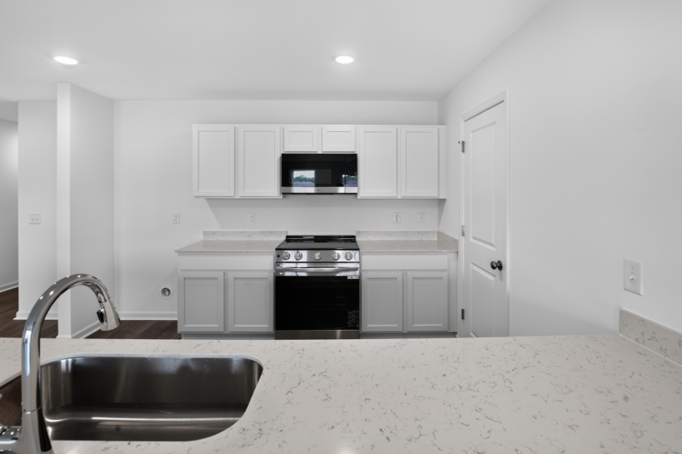 A kitchen with white cabinets.