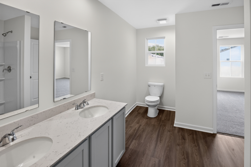 A bathroom with a toilet and sinks.