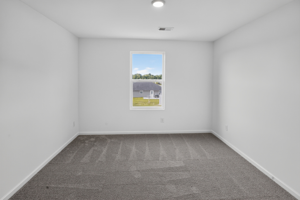 A room with a window and a painting on the wall.
