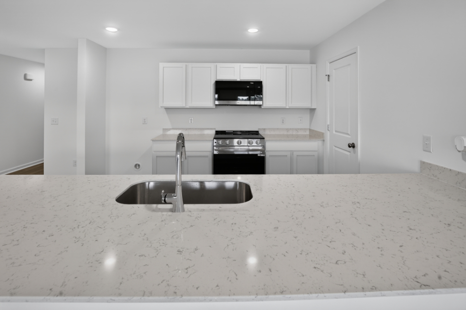 A kitchen with white cabinets.
