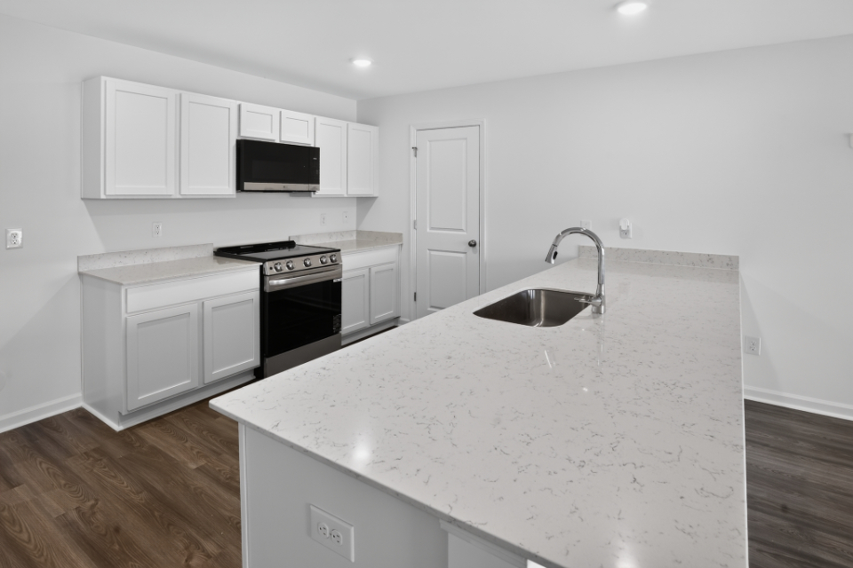 A kitchen with white cabinets.