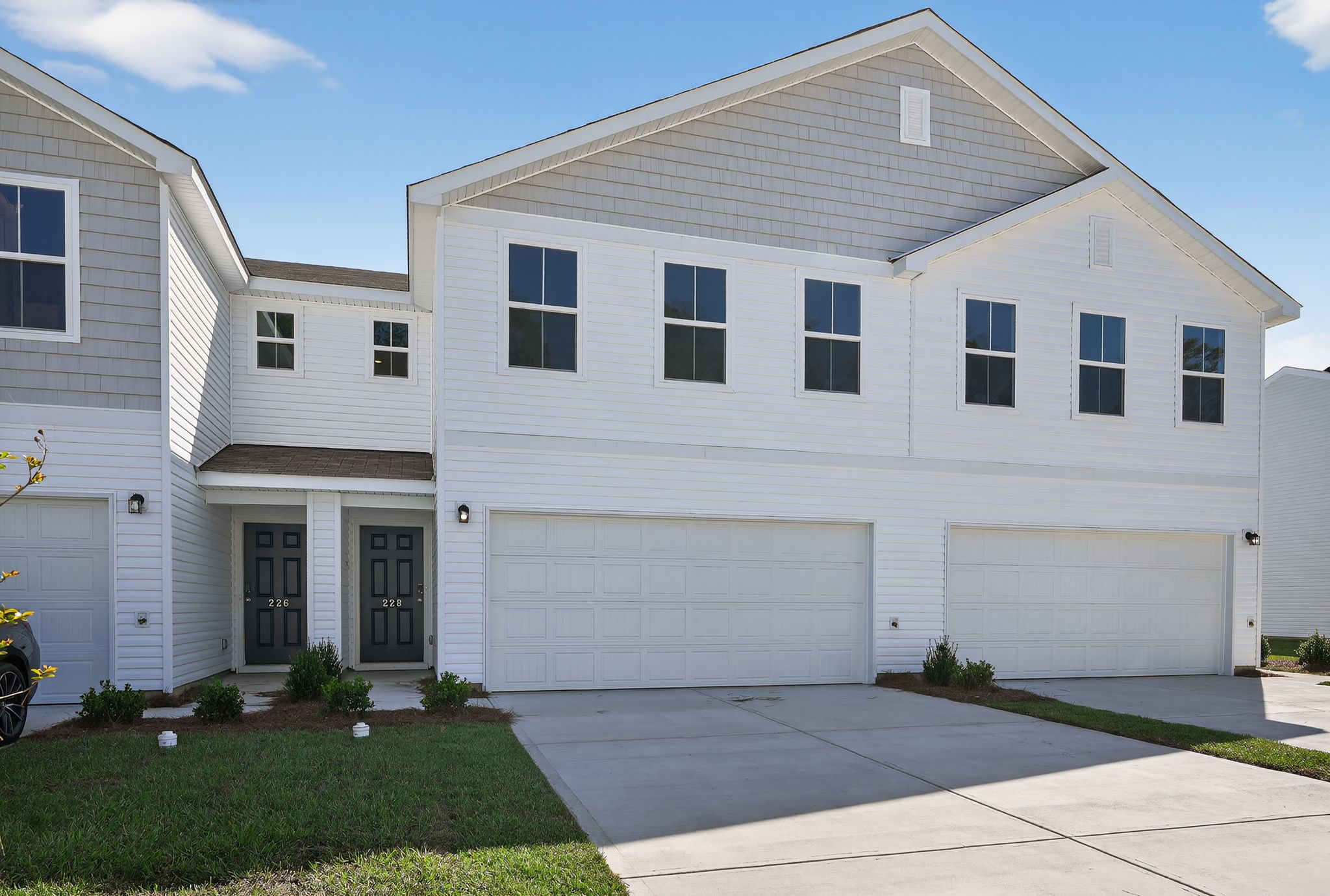 A white house with garages.