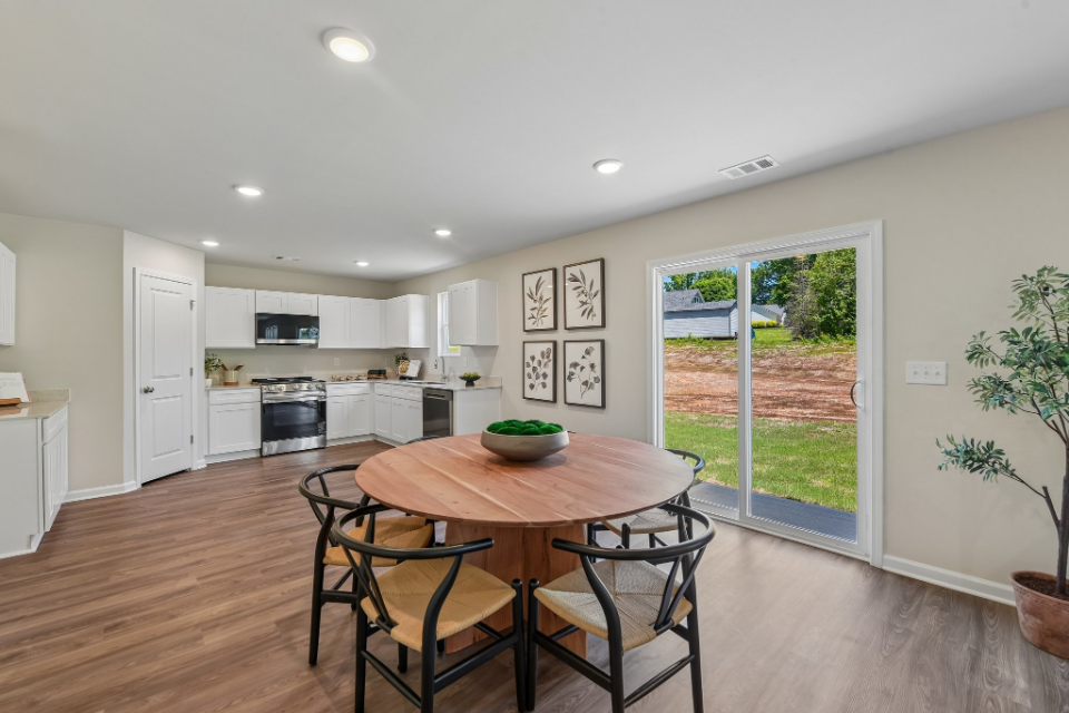 A kitchen with a table and chairs.