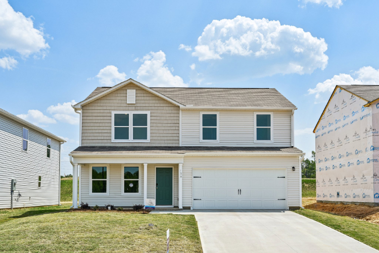 A house with garages and grass.