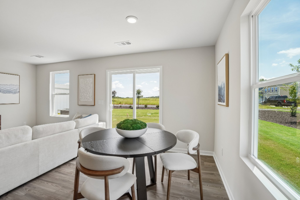 A living room with a table and chairs.